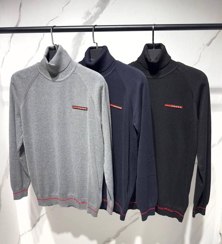 Prada - Pull à col roulé en coton orné du logo Prada en rouge. Gris / Bleu Marine / Noir